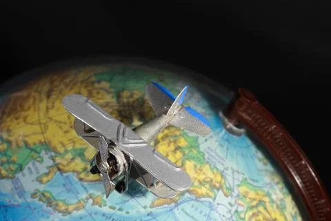 Airplane on globe Stock Photos