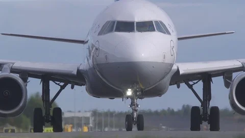 Airplane on ground low angle front view move forward turn at end Video stock 80058646