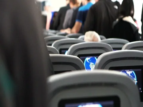 Airplane interior RF view of seats, windows and passenger in queue after arrival Stock Footage 74942400