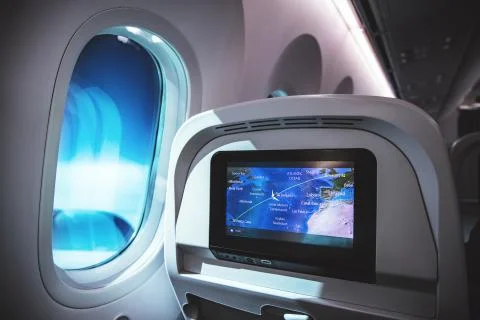 Airplane interior with seats, window inside an aircraft and multimedia screen Stock Photos
