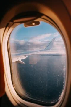 Airplane interior with window view of the Baltic sea and clouds. Stock Photos