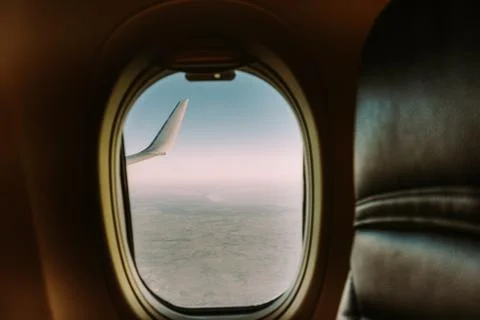 Airplane interior with window view over clouds. Concept of travelling. Stock Photos