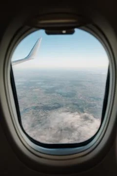 Airplane interior with window view over clouds. Concept of travelling. Stock Photos