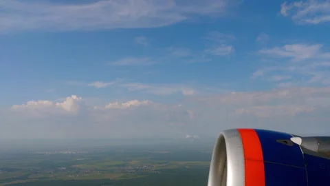 Airplane jet engine view from window in flight over green countryside Stock Footage 347743692