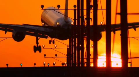 Airplane jet plane landing in airport at sunset, flying into sun. Slow motion. Stock Footage 36052491
