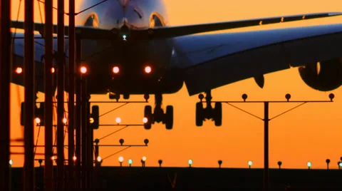 Airplane jet plane landing in airport at sunset, flying into sun. Slow motion. Stock Footage 37149346