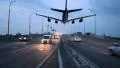 Airplane landing above city highway, transportation traffic dusk HD Footage