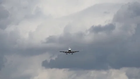 Airplane landing in front of clouds Stock Footage 76563762