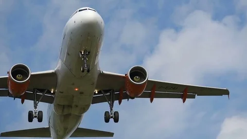 Airplane landing in front of clouds Stock Footage 76564117