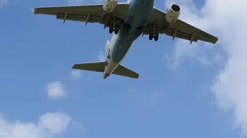Airplane landing in front of clouds Stock Footage 76564325