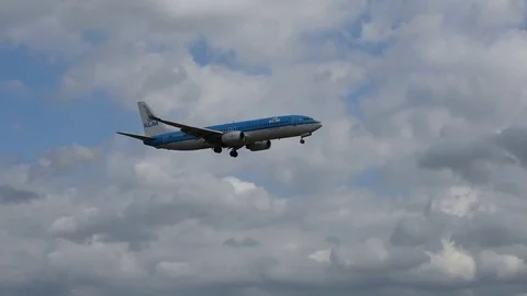 Airplane landing in front of clouds Stock Footage 76564755