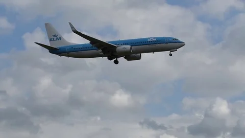 Airplane landing in front of clouds Stock Footage 76564845