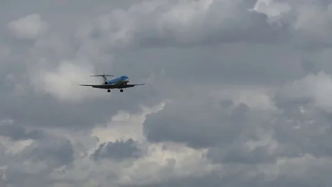 Airplane landing in front of clouds Stock Footage 76565128