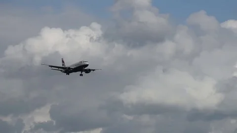 Airplane landing in front of clouds Stock Footage 76565146