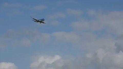 Airplane landing in front of clouds Stock Footage 76565292