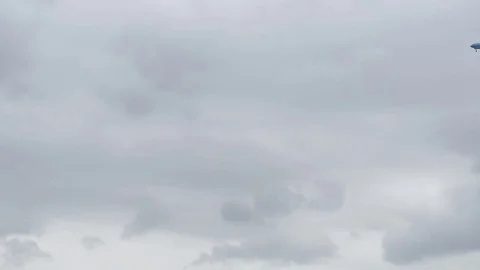 Airplane landing in front of clouds Stock Footage 76565836