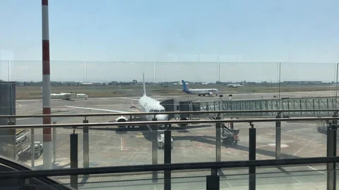 An airplane lands on the runway while other aircraft are preparing for take-off. Stock Footage 94131126