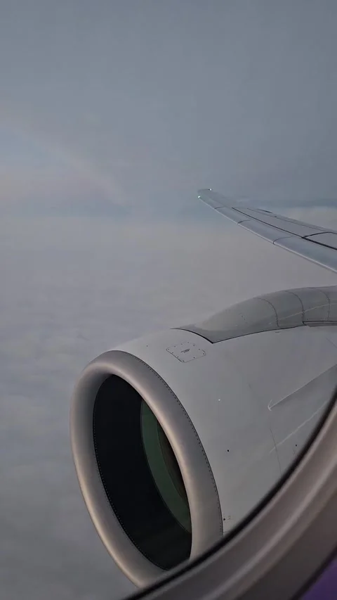 An airplane moves above a cloud layer during a sunset flight over Europe. View f Vídeo Stock 335317657