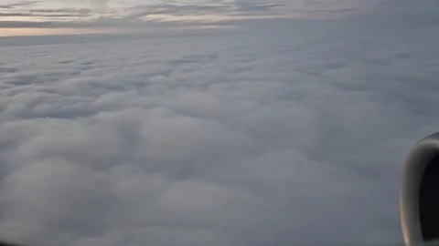 An airplane moves above a cloud layer during a sunset flight over Europe.  Vídeo Stock 335317667