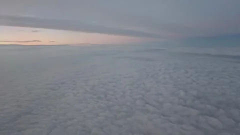 An airplane moves above a cloud layer during a sunset flight over Europe. View f Vídeo Stock 335317705