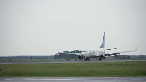 The airplane is moving on the runway against the background of the forest and Stock Footage 83826242
