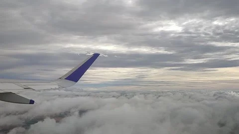 Airplane moving through clouds and blue sky, view from window, FullHD 1080p Stock Footage 138680131