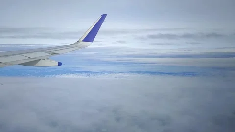 Airplane moving through clouds and blue sky, view from window, FullHD 1080p Stock Footage 138680852
