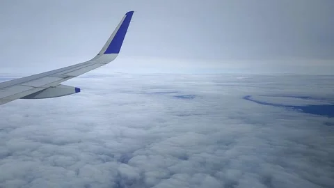 Airplane moving through clouds and blue sky, view from window, FullHD 1080p Stock Footage 138681956