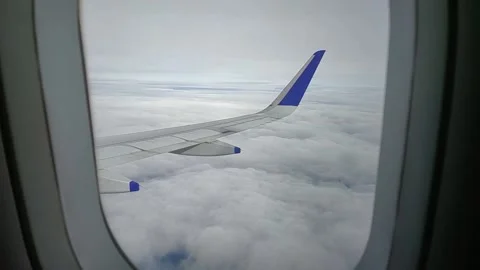 Airplane moving through clouds and blue sky, view from window, FullHD 1080p Stock Footage 138682133