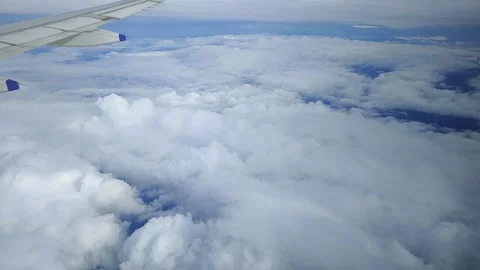 Airplane moving through clouds and blue sky, view from window, FullHD 1080p Stock Footage 138682349