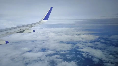 Airplane moving through clouds and blue sky, view from window, FullHD 1080p Stock Footage 138682673