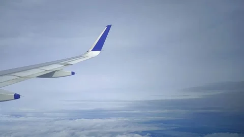 Airplane moving through clouds and blue sky, view from window, FullHD 1080p Stock Footage 138683196