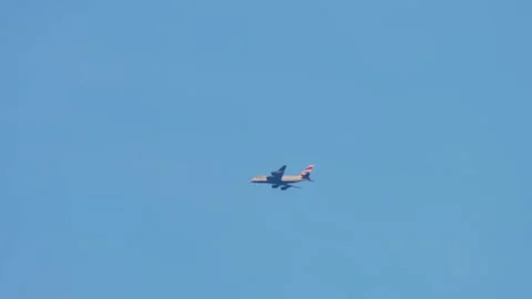 Airplane operating long distance route across open blue sky. Large four engine Видео 331160176