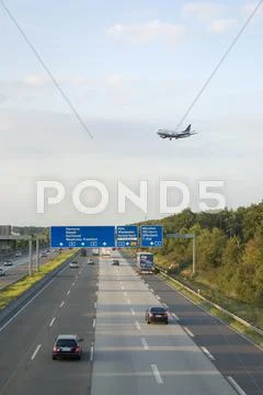Airplane over freeway Stock Photos