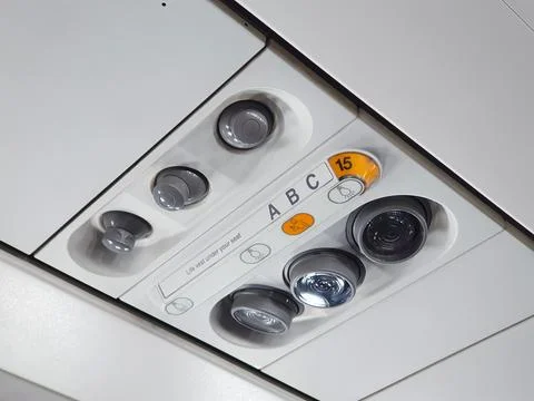 Airplane overhead service panel with reading light and air vent nozzle Stock Photos