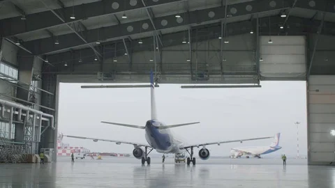 Airplane parking in the airport hangar. Airplane in hangar, rear view of Stock Footage