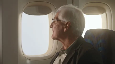 Airplane passenger, older man looking out the window of airplane happy Stock Footage 233640083