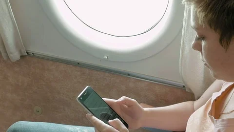 Airplane passenger scrolling through smart phone Stock Footage 69998554