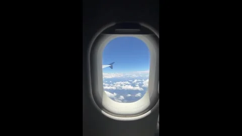 Airplane Passenger Window 747 Wing Above the Clouds. Sun Shade Up. Aerial F.. Stock Footage 339295760