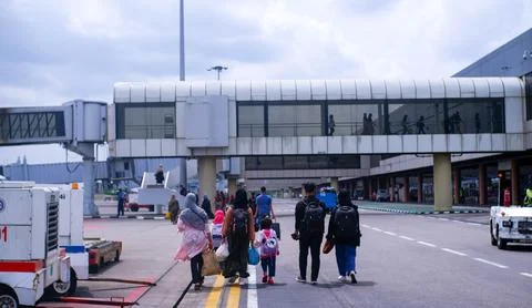 Airplane passengers walk to the arrival hall Stock Photos