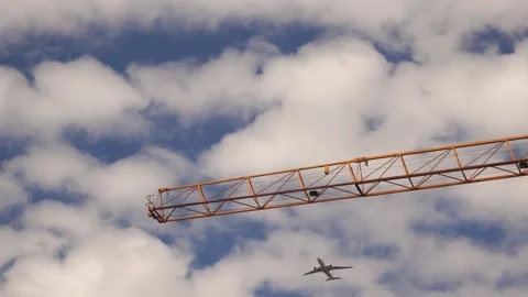 Airplane passes over the construction crane. Stock Footage 159837209
