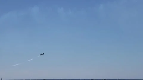 Airplane performs aerobatic stunts leaving smoke trails over ocean and beac.. Stock-Footage 333943395