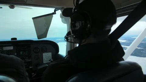 Airplane pilot in flight close-up daylight.Young beard man wearing headphones Stock Footage 253240626