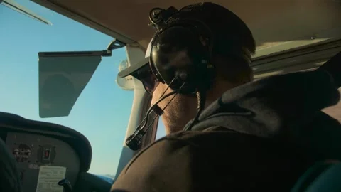 Airplane pilot in flight close-up daylight.Young beard man wearing headphones Stock Footage 253240729