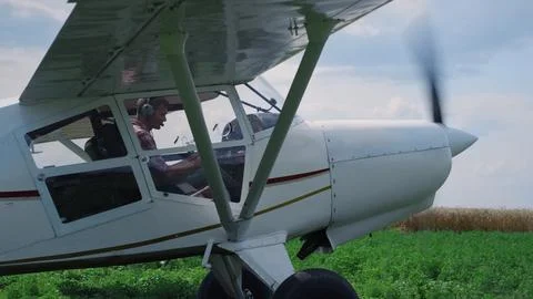 Airplane pilot turning off engine after landing on field. Man parking aircraft. 写真素材