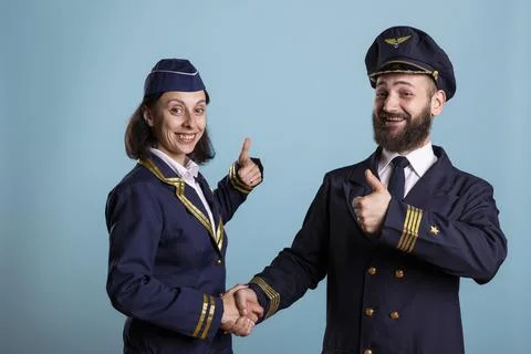 Airplane pilots shake hands while giving thumbs up Stock Photos