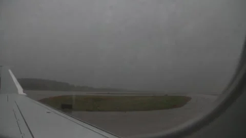 Airplane prepares to take off in the rain Stock Footage 154567396