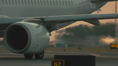 Airplane preparing for takeoff at airport during sunset with clear sky and Stock Footage 335477847