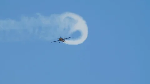 Airplane with propeller in slow motion draws smoke patterns in sky showing loops Stock Footage 120603753