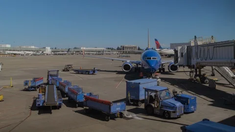 Airplane pulls up to gate at airport and waits on tarmac Stock Footage 100860965